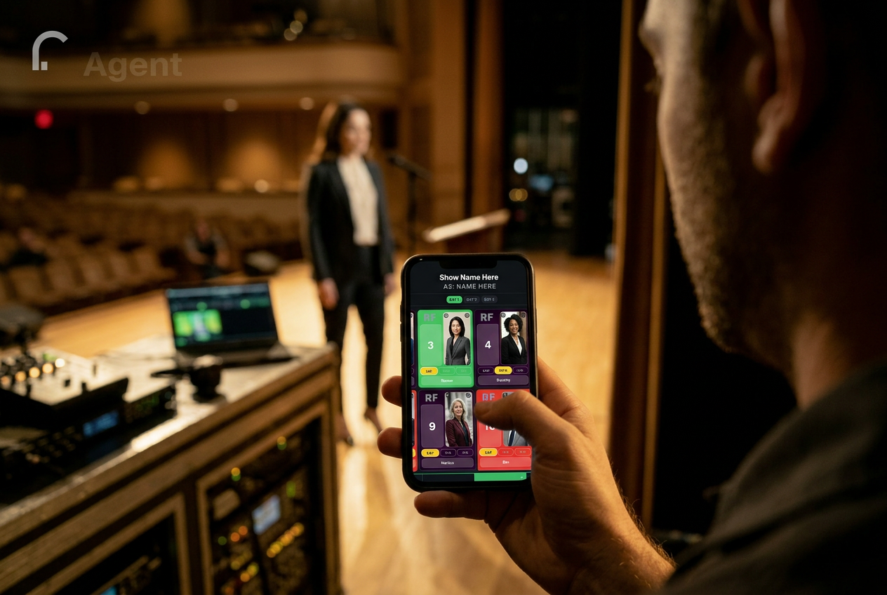 A2 engineer holding a phone running MicTrac backstage, with the talent visible at the lectern in the background